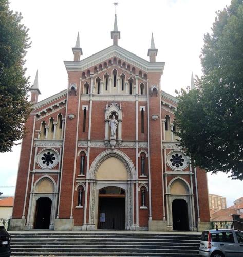 a large brick building with a statue in front of it at Guest House Montebello in Asti