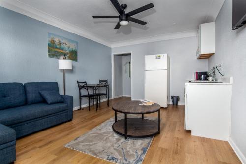 a living room with a blue couch and a table at Pousada Suites at Hollywood Beach in Hollywood