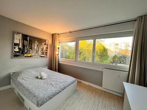 a bedroom with a bed and a large window at Spacieux et Moderne - proche de paris in Evry-Courcouronnes