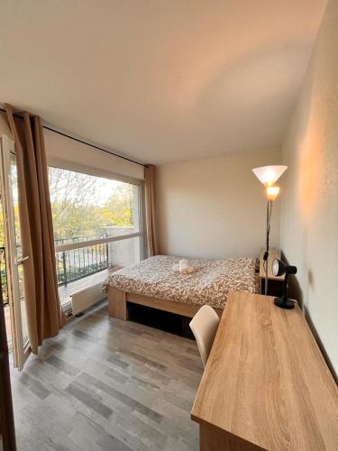une chambre avec un lit et une grande fenêtre dans l'établissement Spacieux et Moderne - proche de paris, Évry-Courcouronnes