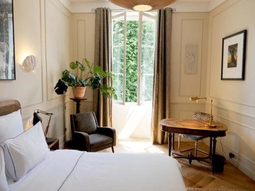 a bedroom with a bed and a desk and a window at Hôtel Bristol Pau in Pau
