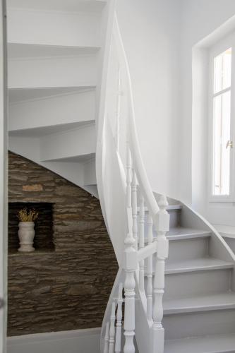 a white staircase with white railings in a house at Athena's Archontiko Master Floor in Andros