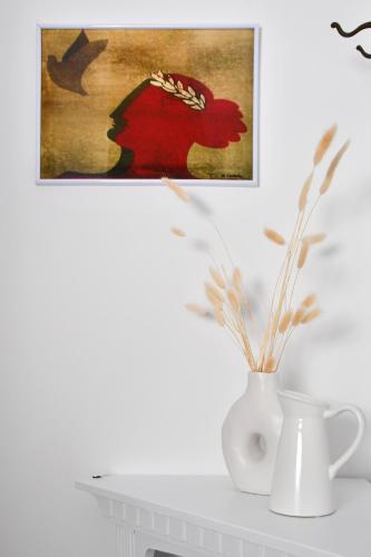 a painting of a woman with a crown on her head and a vase at Athena's Archontiko Master Floor in Andros