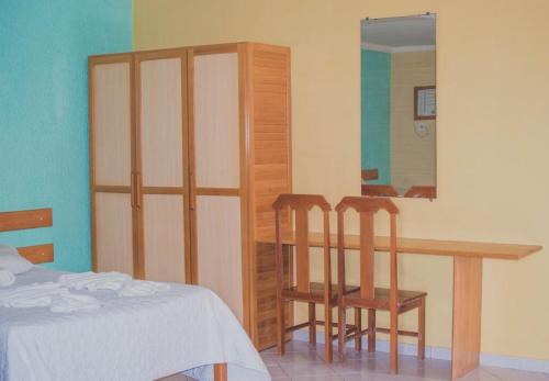- une chambre avec une table, deux chaises et un miroir dans l'établissement Costa Marlin Hotel, à Guriri