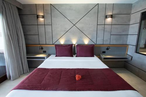 a bedroom with a large white bed with purple pillows at Pousada da Torre in Morro de São Paulo