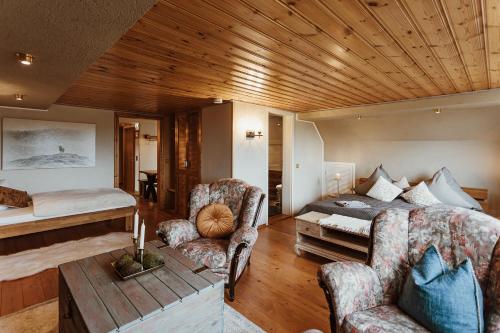 a living room with a bed and a couch at Pension Goldbachmühle in Blankenburg