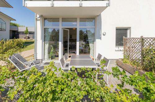 um pátio com cadeiras e uma mesa em frente a uma casa em Kranichrast am Roebeler Stadthafen em Röbel