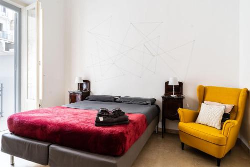 a bedroom with a bed and a yellow chair at Nena House in Bari