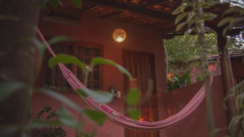 a hammock in front of a house at Pousada Donalu - Ótima Localização in Vale do Capao