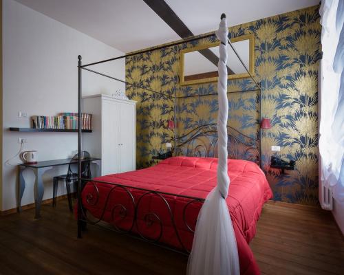 a bedroom with a red bed with a red blanket at B&B Borgo Castello in Marostica