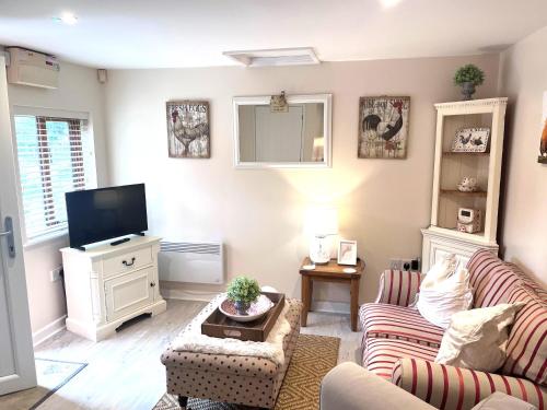 a living room with two couches and a flat screen tv at Bridge Farm Holiday Cottages in Cow Honeybourne