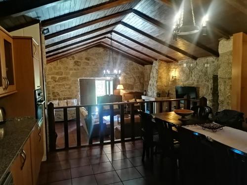 eine Küche und ein Esszimmer mit Tisch und Stühlen in der Unterkunft Casa de Férias do Parque da Peneda Gerês in Vila Verde