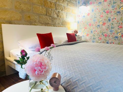 sypialnia z łóżkiem z zegarem i kwiatami na stole w obiekcie Pension22 w mieście Miśnia