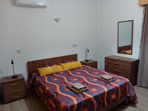 a bedroom with a bed with two dressers and a mirror at Pari Holiday apartments in Paphos