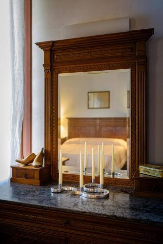 a bedroom with a large mirror and candles on a table at B&B Borgo Castello in Marostica