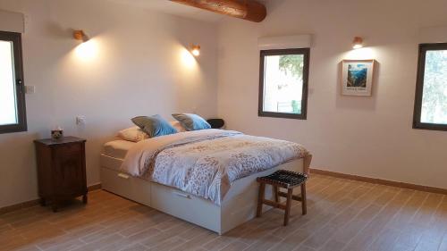 une chambre avec un lit et deux fenêtres dans l'établissement Mas Corsin, à Piolenc
