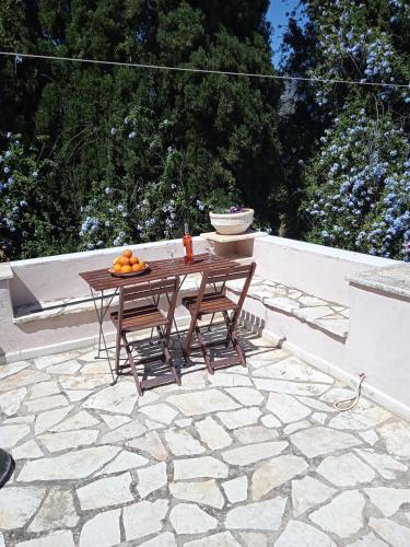 a table and two chairs on a stone patio at Alegria house with gardens near portoheli in Kranidi
