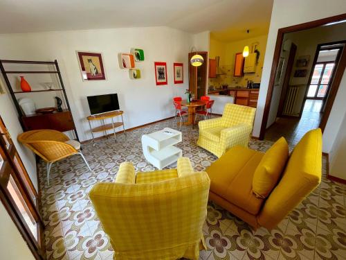 Il comprend un salon doté d'un mobilier jaune et une cuisine. dans l'établissement SG Family - Casa di Tulu', à Peschiera del Garda