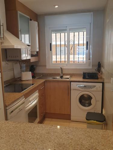 een keuken met een spoelbak en een wasmachine bij Holidaytorremar-84-MED021 in El Borseral
