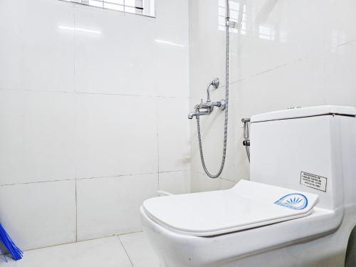 a white toilet in a bathroom with a shower at Villa Espoir By Alchemy Homes in Ernakulam