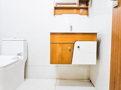 a kitchen with a wooden cabinet and a sink at Villa Espoir By Alchemy Homes in Ernakulam