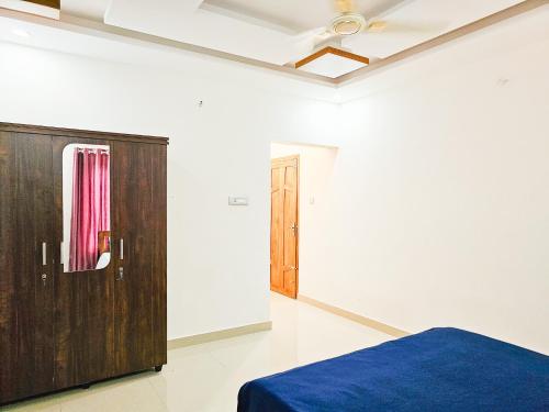 a bedroom with a bed and a wooden cabinet at Villa Espoir By Alchemy Homes in Ernakulam