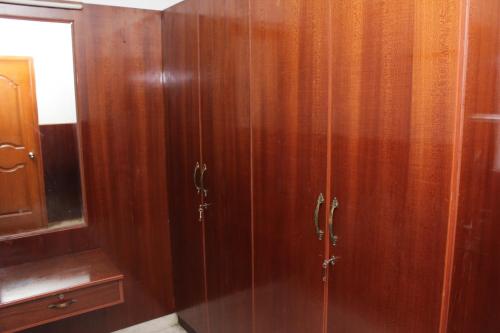 a wooden cabinet with a glass door in a bathroom at Happy Planet in Chennai