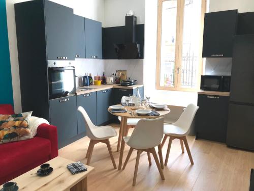 une cuisine avec une table et des chaises dans une pièce dans l'établissement Appartement Confortable Mansord, Allevard, à Allevard