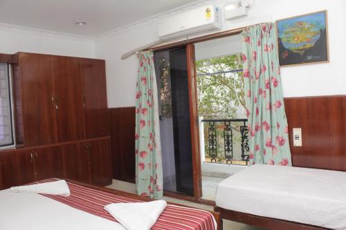 a bedroom with two beds and a window at Happy Planet in Chennai