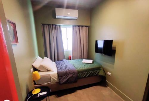 een kleine slaapkamer met een bed en een raam bij Hotel Windsor Mendoza in Mendoza
