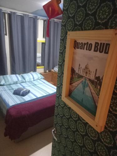 a bedroom with a bed and a picture on the wall at Hostel Trilhas e Rotas - a 150m da Avenida Paulista in Sao Paulo