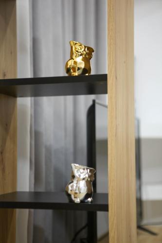 Deux vases d'or sont assis sur une étagère dans l'établissement Green-Garden Apartmets, à Saranda