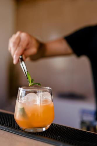 a person stirring a drink with a spoon at Naxos Finest Hotel & Villas in Naxos Chora