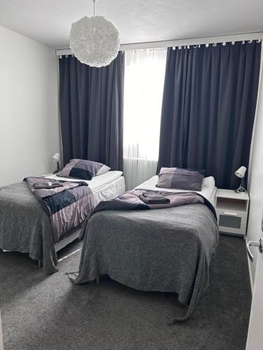 1 dormitorio con 2 camas y una ventana con cortinas azules en BlueSolarPearl C en Tampere