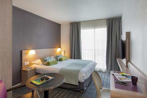 a hotel room with a bed and a table at Best Western Plus La Marina in Saint-Raphaël