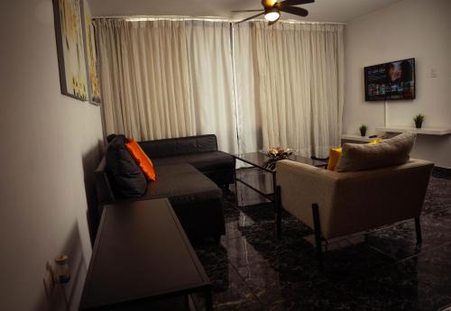 a living room with a couch and a table at Residenciales H1 & H2 - Breakfast & Room Service - Airport close in Santiago de los Caballeros