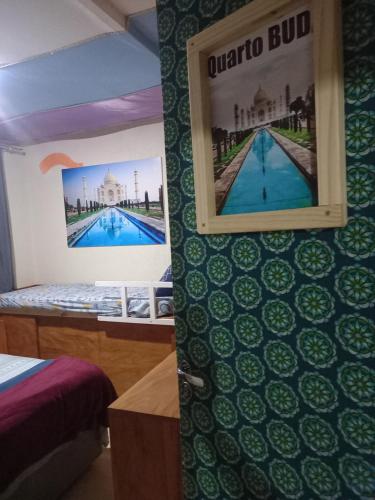 Una habitación con una foto en la pared y una cama en Hostel Trilhas e Rotas - a 150m da Avenida Paulista, en São Paulo