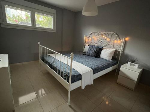 sypialnia z białym łóżkiem z poduszkami i oknem w obiekcie Studio Odysseus w mieście Nikiti