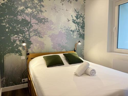 a bedroom with a bed with green and pink wallpaper at Vieux-Lille - Deux pièces de charme in Lille