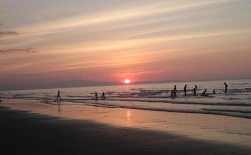 a group of people playing in the water at the beach at Chantal Beach House in San Fabian