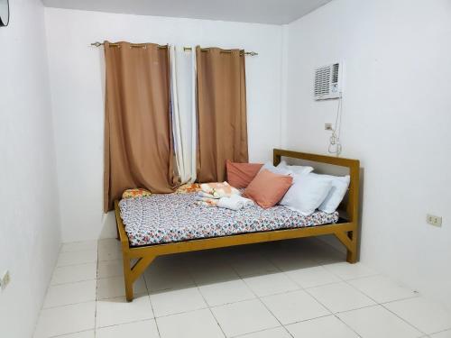 a small child laying on a bed with pillows at Chantal Beach House in San Fabian