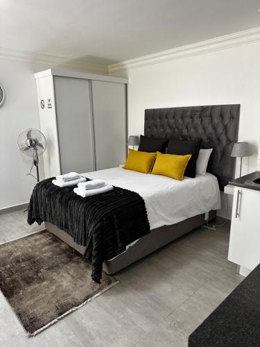 杰米斯顿Marielitsa Guest Suite No 9的卧室里有一张大床，上面有黄色枕头