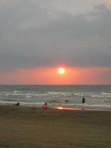 a group of people on the beach at sunset at Chantal Beach House in San Fabian