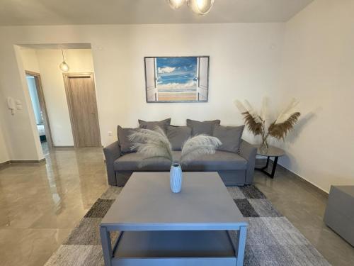 a living room with a couch and a table at Nikiti Sunrise Apartments in Nikiti