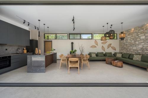 a kitchen and a living room with a table at VILLA PETRA PHILIPPOS heated pool optional in Khámbatha