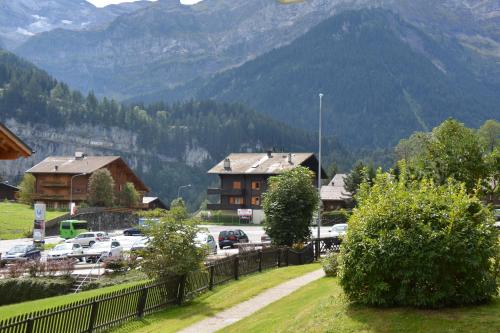 a town with cars parked in a parking lot with mountains at Apartment Champéry Grand Pré A in Champéry
