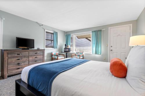 ein Schlafzimmer mit einem großen Bett und einem TV in der Unterkunft The Lighthouse Inn & Suites in York Beach