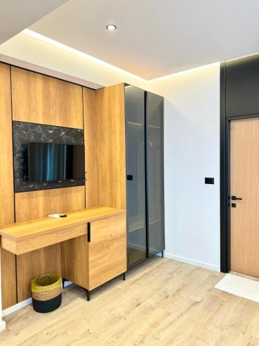 a room with a desk with a tv on a wall at Hotel Joni Premium in Ksamil