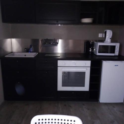 a kitchen with a white stove top oven next to a microwave at gite odeau in Sargé-sur-Braye