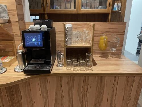 a counter with a laptop and glasses on it at Hotel König Humbert in Erlangen